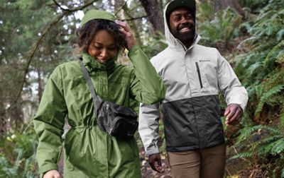 Couple in a forest wearing a water resistant Columbia Sportswear jackets.