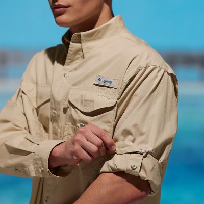 Model showing how to pull the snap tab holder over the rolled up sleeve of the shirt.