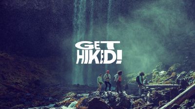 Video of younger, happy hikers blazing through a Pacific Northwest wooded area with waterfalls and beautiful vistas.