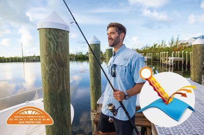 Model in profile casting a line in the blue Bahama shirt. Omni-Shade logo is on the bottom left and a graphic showing how the sun's rays are blocked by fabric is on the bottom right.