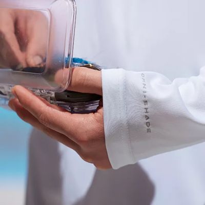 Close up of hands holding a tackle box with extended sleeves.