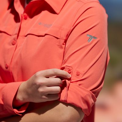 Model showing how to pull the snap tab holder over the rolled up sleeve of the shirt.