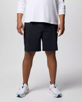 Waist-down image of a man wearing black shorts and white sneakers.