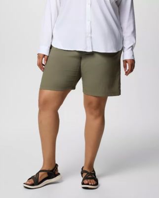 Waist-down image of a woman wearing green shorts and sandals.