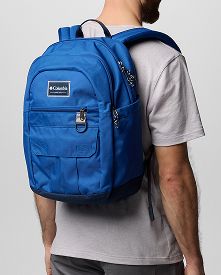 A back view of a person wearing a blue backpack.
