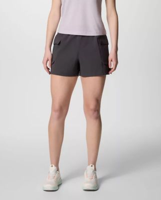 Waist-down image of a woman wearing grey shorts and sneakers.