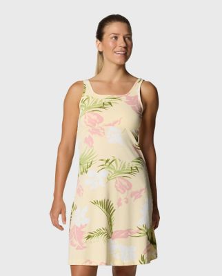 A woman wearing a floral dress with sandals.