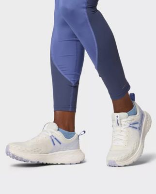A white trail running shoe.