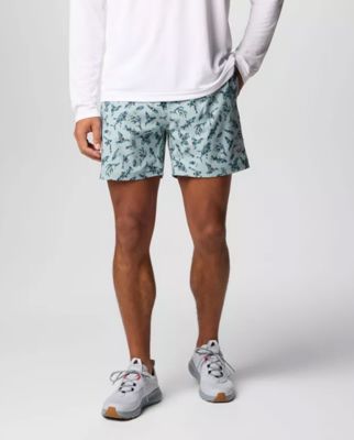Waist-down image of a man wearing printed shorts and sneakers.