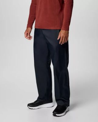 Waist-down image of a man wearing navy pants and sneakers.