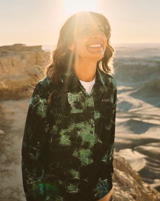 ⁨A woman in sun protection gear in the desert.