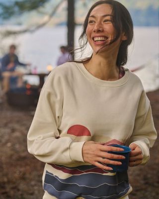 Woman in the woods enjoying a cup of coffee.