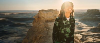 A woman hiking in the desert wearing sun blocking gear.