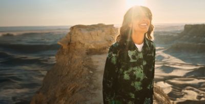 A woman hiking in the desert wearing sun blocking gear.