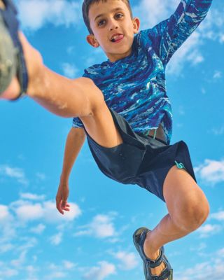 A boy leaping over the camera.