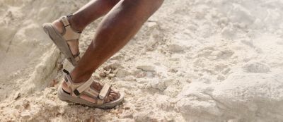 A man in sandals hiking the desert.