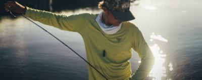 Man fishing on a sunny day in Performance Fishing Gear with text: NEW FOR SUMMER