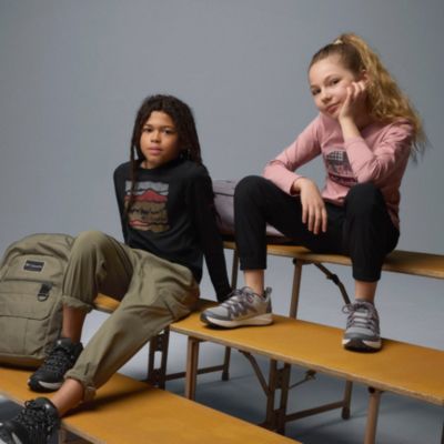 Two kids sitting on risers in back-to-school gear.