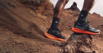 A close up of hiking sneakers on rocky terrain