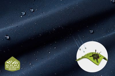 A close-up of droplets beading on fabric with the Omni-Shield logo in the bottom left while a graphic shows the rain-and-stain repellency in the bottom right.