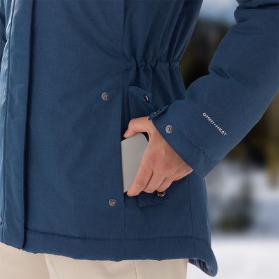 Close-up of a model putting her phone in the pocket and showing the drawcord adjustable waist.