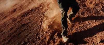 Hiker running down a rugged trail.