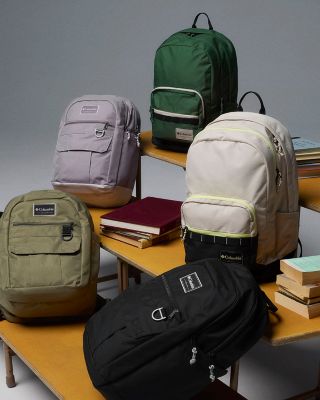 Collection of backpacks and books on bleachers.