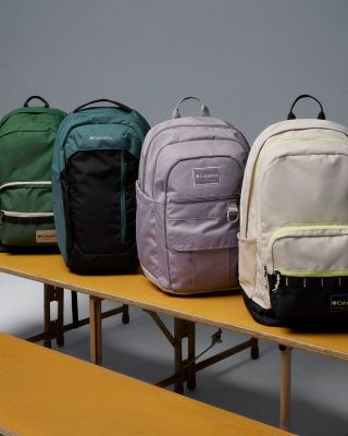 Collection of backpacks and books on bleachers.