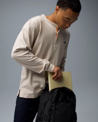 A man holding a backpack.