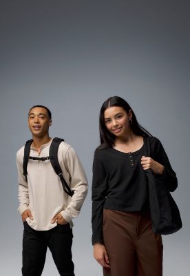 Two students smiling, wearing backpacks.