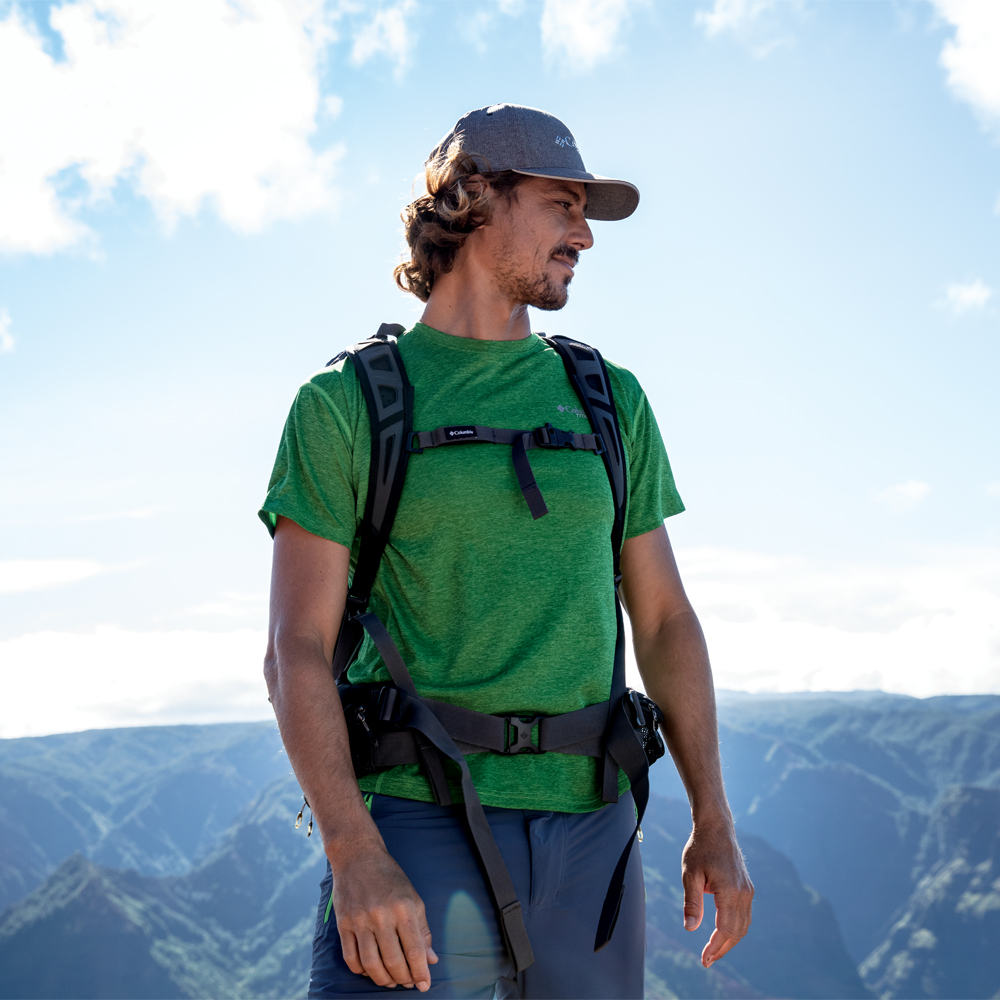 Un uomo in piedi davanti a un paesaggio montuoso sullo sfondo

