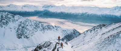  Two people in Columbia gear hiking in a snow-covered mountain range