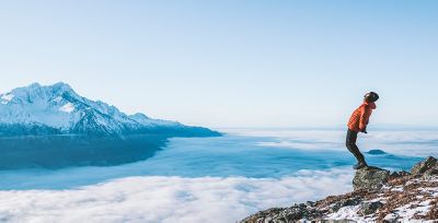 A man in Columbia gear standing on a mountaintop. 