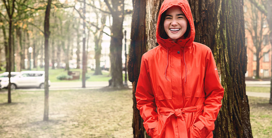Woman in a park wearing a red Columbia Sportswear jacket.