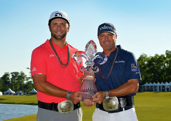 Jon Rahm and Ryan Palmer at the 2019 Zurich Classic holding a trophy. 
