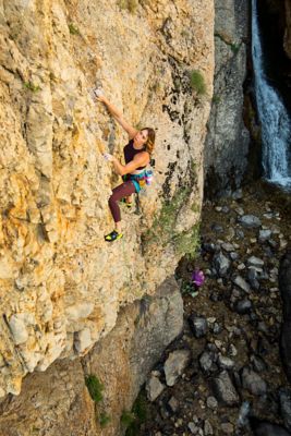 Nikki scaling a rock wall