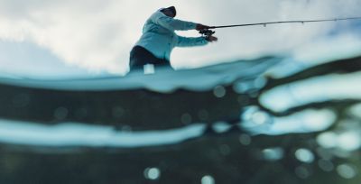Video still of a person fishing from a boat. 