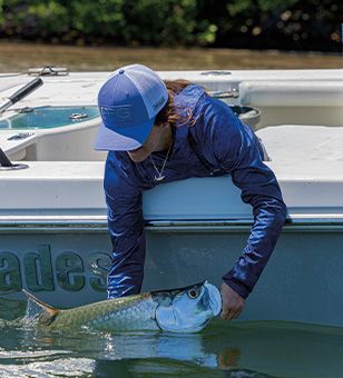 A woman fishing from a boat. 