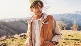 A man wearing a brown vest on a hillside