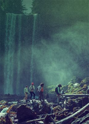 Hikers walking in front of a waterfall