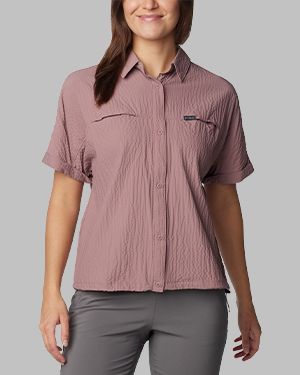 Woman in a light pink textured button-up shirt.