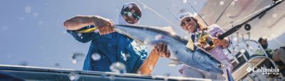 Two people holding a fish on a boat