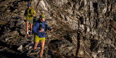 Two runners trail running in the Kor AirShell hoody in the high alpine.