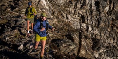Two runners trail running in the Kor AirShell hoody in the high alpine.
