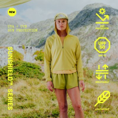 NEW SUNSHIELD™ SERIES. UVA + UVB SUN PROTECTION. UP50, BREATHABLE, LIGHTWEIGHT. On model shot of the Sunshield Hoody in the mountains.