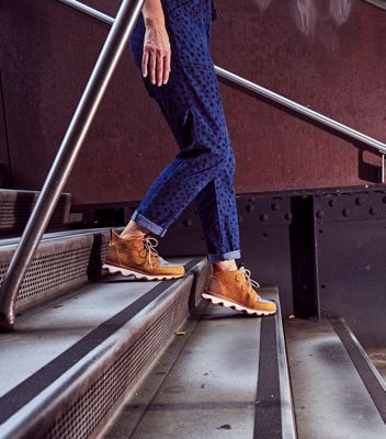 Women wearing Kinetic Caribou boots walking down the stairs outside the during the SOREL Mile-Long Runway event