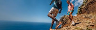 Two people hiking on a rocky trail with Summer Sale Up To 50% Off