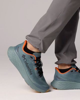 A knee down image of pants and sneakers