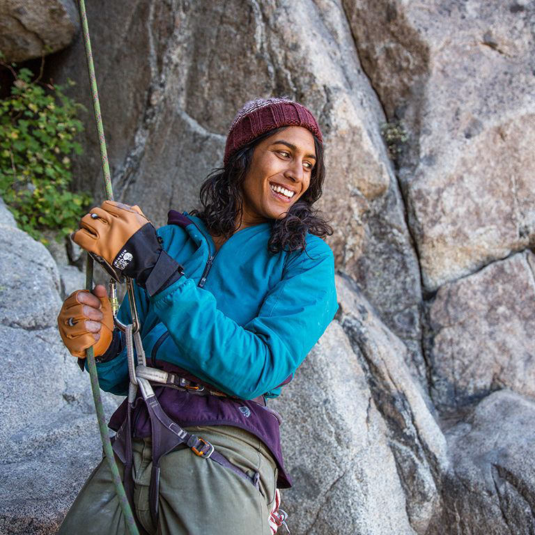 Smiling belayer wearing the Women's Kor Strata™ Climb Hoody at Donner Pass.